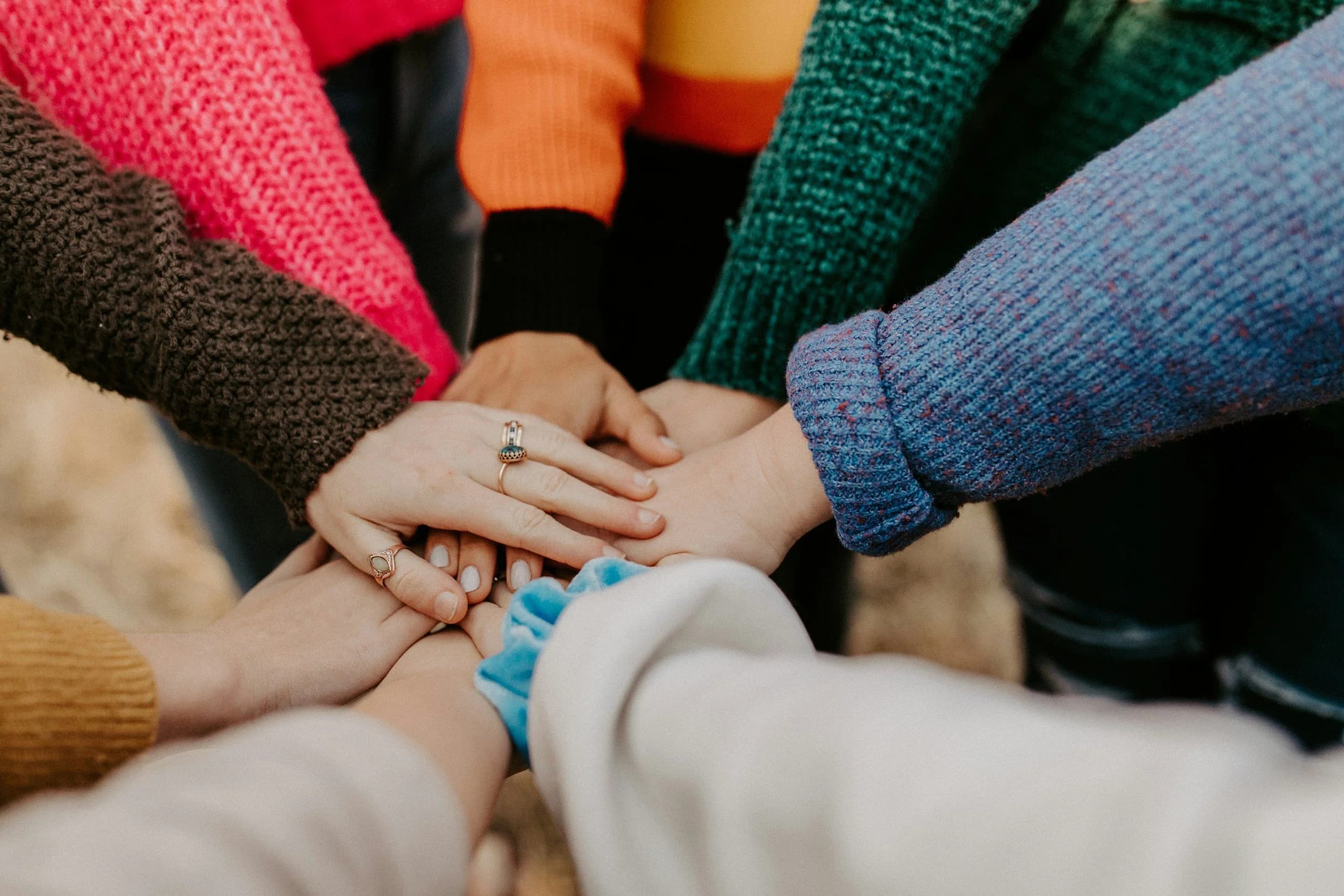 Diverse hands stacked together in unity.